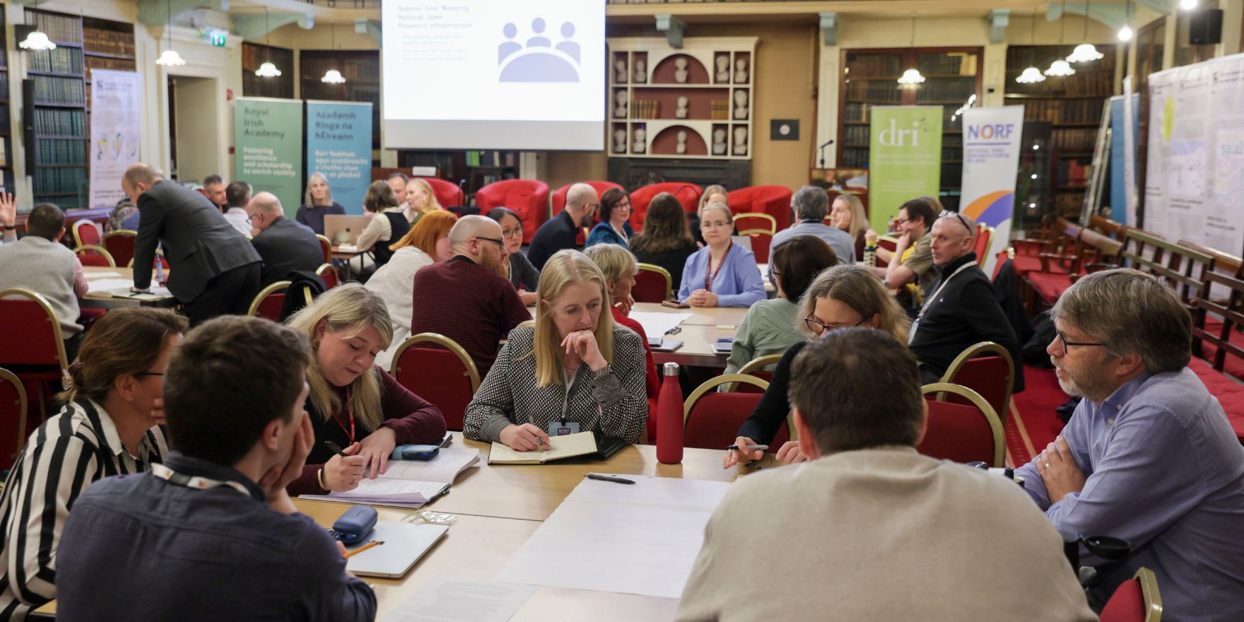 Attendees of the NORF Workshop sitting at tables in the Meeting Room of the Royal Irish Academy, discussing the topics of the day.