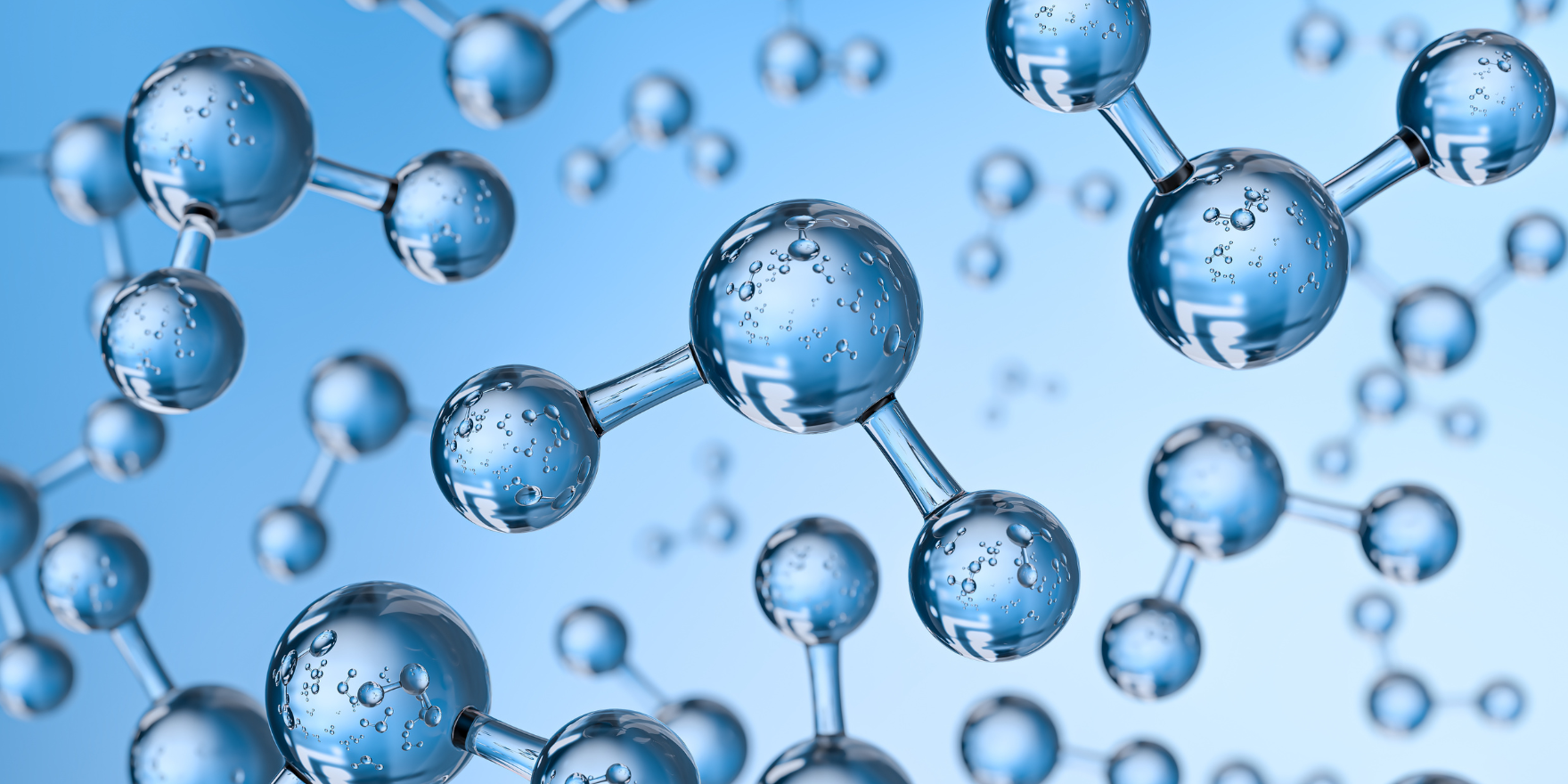 3D-rendered illustration of water molecules, depicted as transparent blue spheres connected by thin rods, representing hydrogen and oxygen atoms. The molecules appear suspended in space against a light blue gradient background. Small water droplets are visible inside the spheres, enhancing the visual effect.