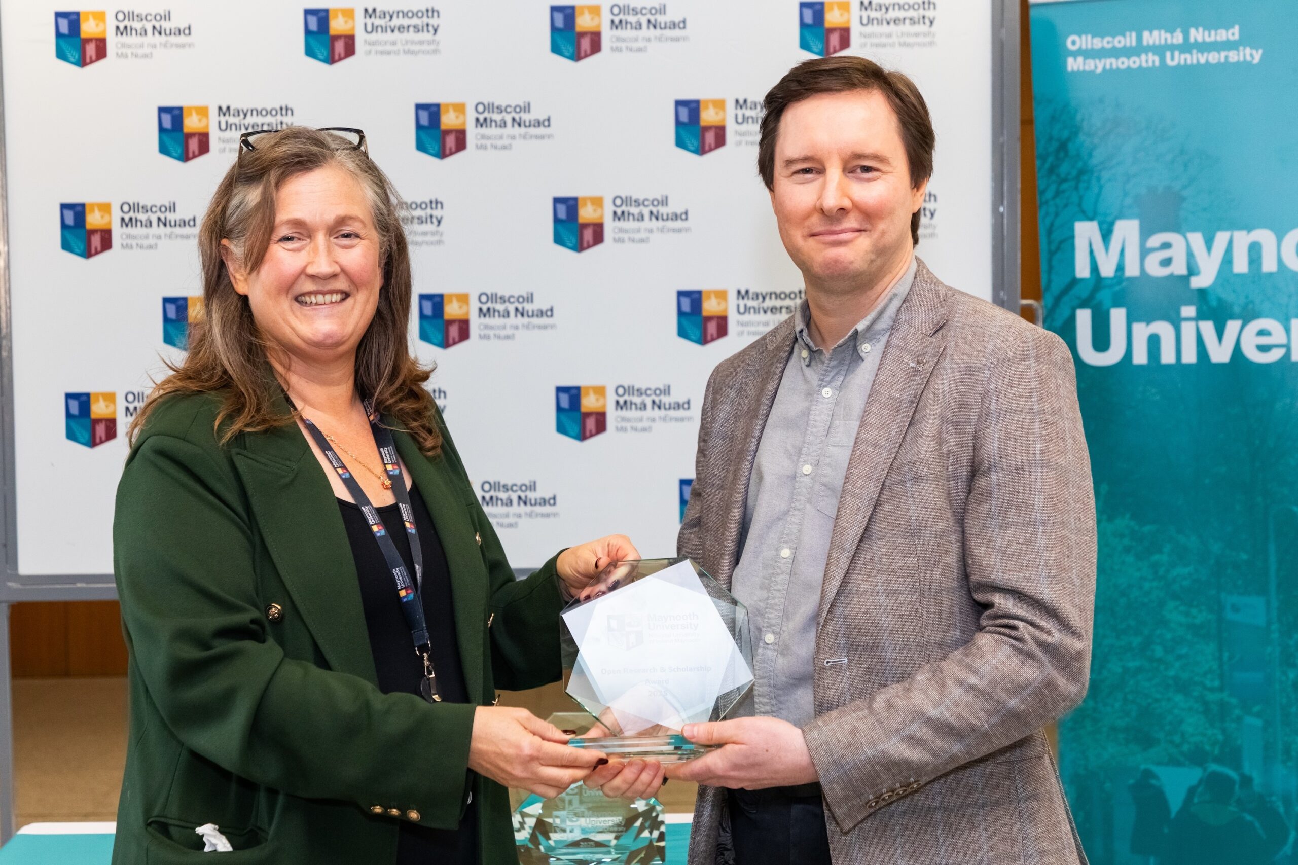 Professor Rachel Msetfi, Vice President for Research and Innovation, Maynooth University awarding Dr Demot Lynott with the Open Research & Scholarship Award. They are both smiling at the camera with the award held in both their hands.